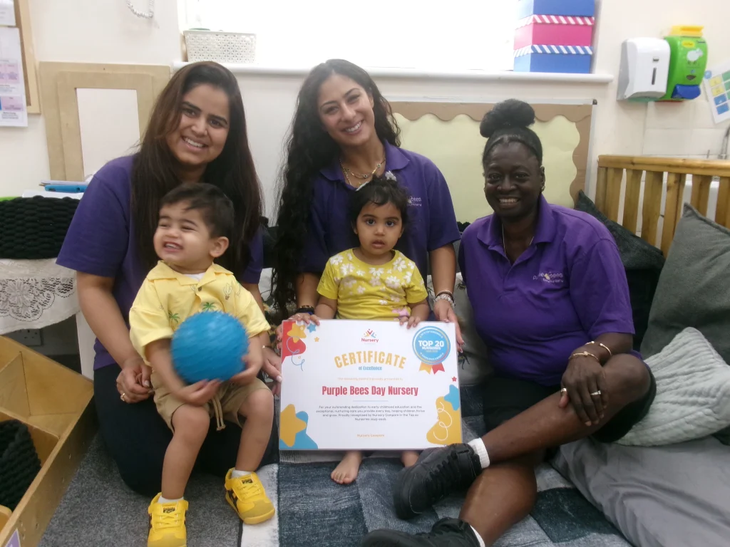 Purple Bees Day Nursery staff member and child holding the nursery's Top 20 award certificate